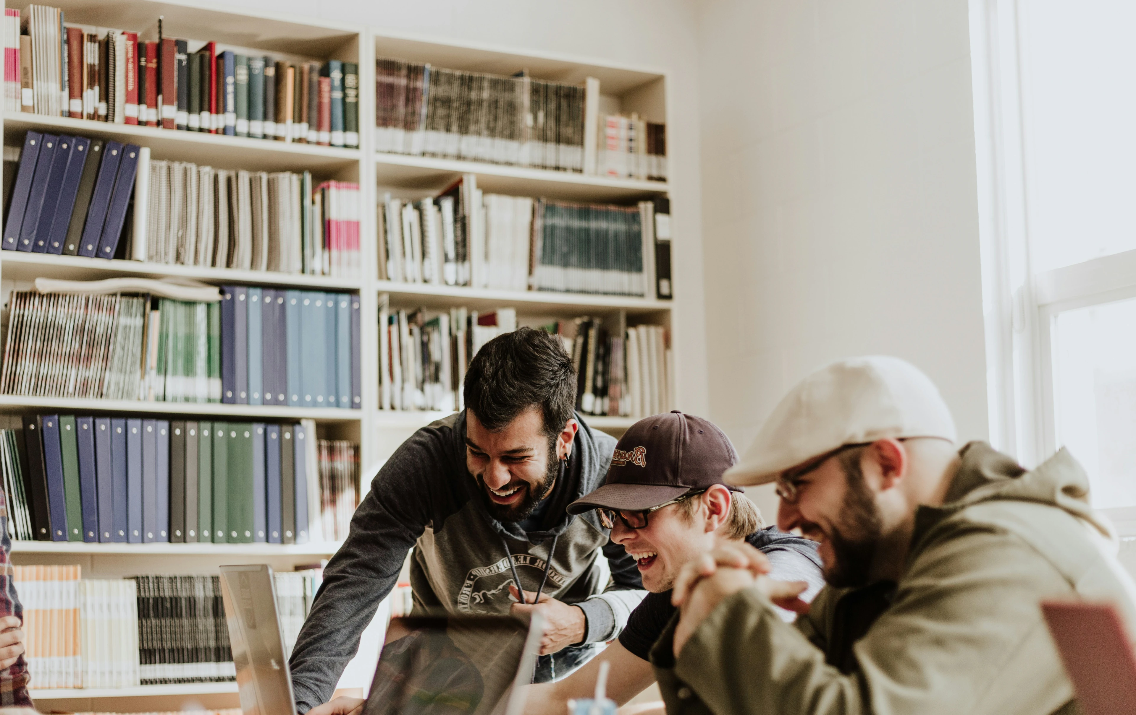 People collaborating around a laptop, laughing together